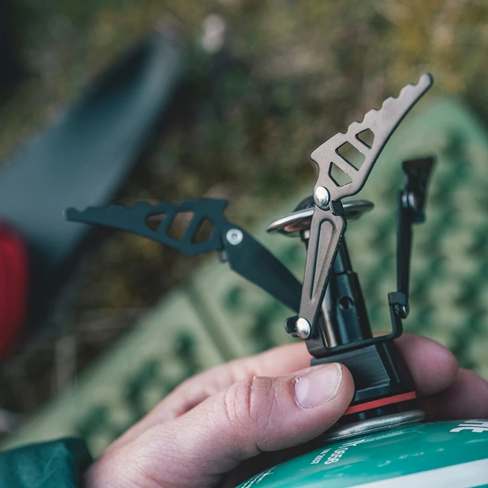 Nahaufnahme eines Gaskochers Firefly, ideal für Motorrad-Camping, mit detaillierter Ansicht der robusten Konstruktion und ergonomischen Handhabung.