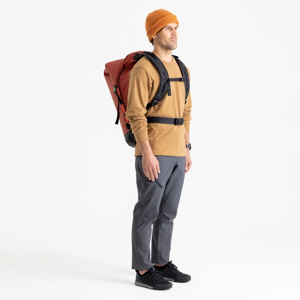 Mann trägt einen Big River Dry Backpack 75 Liter, ideal für Motorrad-Camping, in einem Studio. Der Rucksack ist groß und bietet viel Stauraum. Der Mann hat eine orangefarbene Mütze, ein braunes Oberteil und graue Hose an.