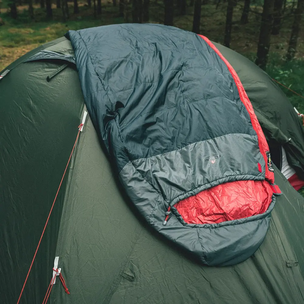 Schlafsack Moraine I 11° auf einem Zelt im Wald, perfekt für Motorrad-Camping.